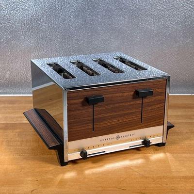 GE TOASTER  |
Vintage General Electric toaster with stainless steel and faux wood paneling, four slice pop up toaster
- l. 9 x h. 6.5 in.