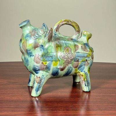 ART POTTERY PIG  |
Colorful pottery pig, appearing to be a watering can, appears to be unsigned - l. 10 x h. 8 1/2 in.