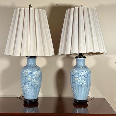 (2pc) PAIR BLUE PORCELAIN LAMPS  |
A pair of blue porcelain table lamps with textured floral decoration mounted on wood stands with...