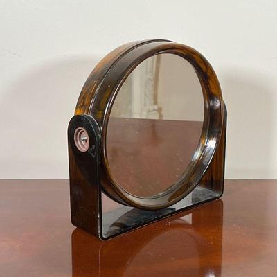 ACRYLIC VANITY MIRROR  |
Faux tortoiseshell brown acrylic, with magnifying mirror and regular mirror, swiveling - l. 9.25 x h. 9.25 in.
