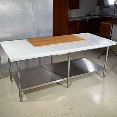 CHEF'S TABLE  |
White tile top with raised outer lip, permanently affixed wood cutting board surface, on an industrial 6 legged...
