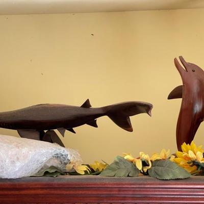 Wood carvings of sea creatures like sharks and dolphin and fish