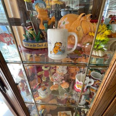 An entire curio cabinet full of Garfield collectibles as well as other cartoon characters 