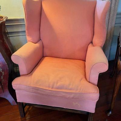 Single peach/pink upholstered wingback chair. 