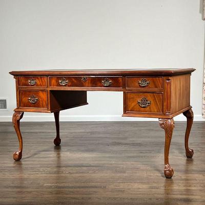 CHIPPENDALE STYLE DESK | Beautifully figured wood, having an inset leather top in three sections, five drawers with brass handles, over...