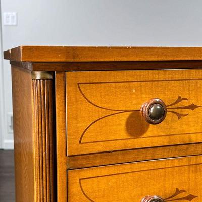 SCHMIEG & KOTZIAN DRESSER | Tiger maple, inlaid in contrasting woods, having a concave front with four graduated drawers with wood pulls,...