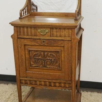1194	ANTIQUE OAK 1 DRAWER STAND HAVING A CARVED DROP FRONT LOWER DOOR AND MIRROR BACK GALLERY, APPROXIMATELY 22 IN X 15 IN X 51 IN H
