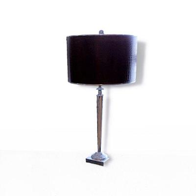 One of a pair of tall chrome lamps with leather shades