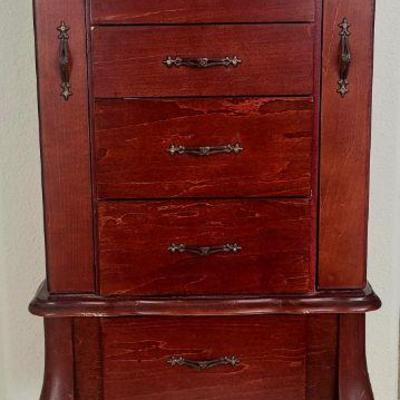 Jewelry armoire.  Has 6 pull out drawers, lines in velvet, two side pullout doors to hang necklaces and more.  A lift top that contains...