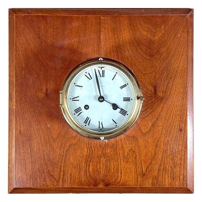 LEXON SHIP'S CLOCK | 6-inch brass ships clock mounted on a wooden plaque, the face with Roman numerals - w. 16 x h. 16 in. 