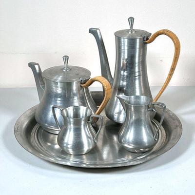 (5pc) MAGNUSSEN PEWTER SERVICE | By Royal Selangor Porcelain, probably Eric Magnussen, including a coffee pot and tea pot with rattan...