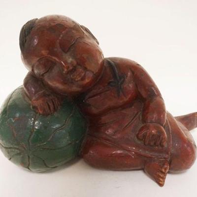 1202	ASIAN WOOD CARVING OF A YOUNG BOY SLEEPING ON A MELON, APPROXIMATELY 14 IN X 10 IN HIGH

