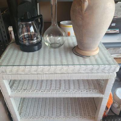 Wicker table with a glass top, decorative pieces and a coffee maker, all sold separately