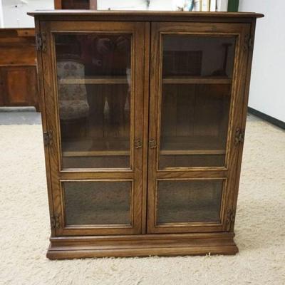 1194	OAK DOUBLE GLASS DOOR BOOK SHELF WITH 2 ADJUSTABLE SHELVES, APPROXIMATELY 26 IN X 13 IN X 44 IN H

