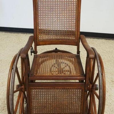 1073	VICTORIAN OAK CANE SEAT WHEEL CHAIR, WOOD WAGON WHEELS, PRESSED BACK DESIGN ON CREST W/BENTWOOD UNDERCARRIAGE
