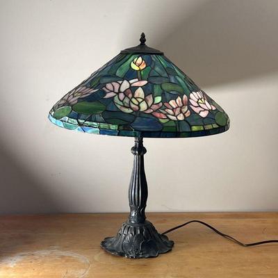 TIFFANY-STYLE STAINED GLASS LAMP | Lily flower stained glass lamp on a cast metal base with lily pad motif
Dimensions: h. 26 x dia. 21 in.
 