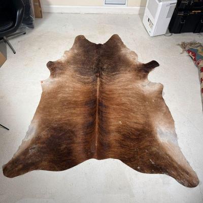 SADDLEMANS STEER HIDE RUG | Free-form cow hide rug, brown with stripes and marked with brand and other labeling on the bottom
Dimensions:...