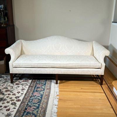 WHITE CAMELBACK SOFA | Chippendale style camelback cushioned white couch with floral designed upholstery and carved wood legs; l. 21 x w....