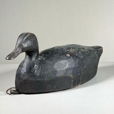 BLACK DUCK DECOY | Chip carved wood decoy duck, black paint, metal ring and lead weight on the bottom. l. 16 x w. 7 x h. 7.5 in  