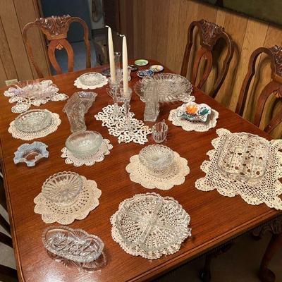 Antique doilies displayed under vintage glass serving pieces 