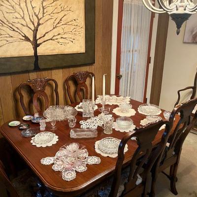 Vintage glass serving pieces displayed on Dining Table. Table doubles in size with 4 extra leaves, 6 chairs and hutch complete the set.