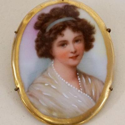 1007	PORCELAIN OVAL BROOCH/PIN W/IMAGE OF YOUNG WOMAN, APPROXIMATELY 2 IN HIGH
