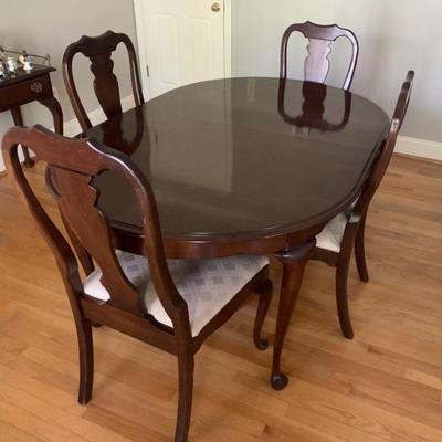 Queen Anne mahogany finish dining table with 3 leaves and pads.  4 chairs.  Excellent condition.