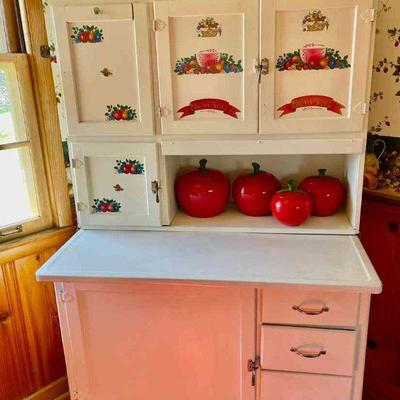 Lot 116-K: Vintage Hoosier Cabinet

Features: 
â€¢	Painted whie with fruit-motif stencils on upper cabinet doors
â€¢	Cabinet table top is...