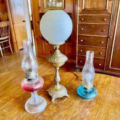Lot 104-BR1: Lamp Trio

Features: 
â€¢	One oil lamp 
â€¢	One electrified oil lamp featuring a blue glass base
â€¢	Antique electric lamp,...