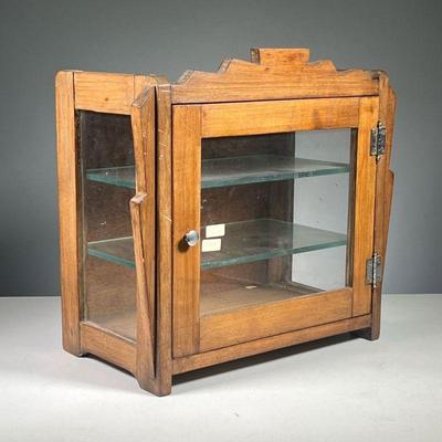 ART DECO TABLETOP DISPLAY CASE | Circa 1920s, wooden display case with glass front door and side panels, with interior glass shelves