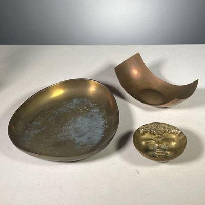 (3PC) COPPER & BRASS VESSELS | Including an R. Schumacher copper crescent bowl, small brass bowl with face relief inside, and a large...