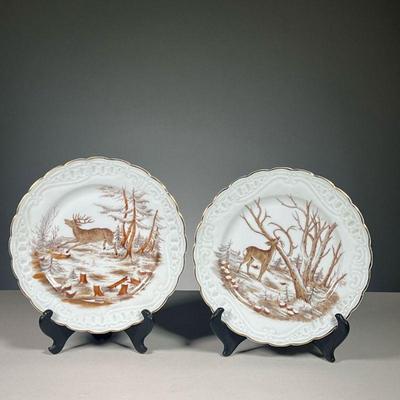 (2PC) PAIR AUSTRIAN DEER PLATES | Hand-painted with scenes of deer running through a snowy forest, with gilt rims, faint impressed stamp...