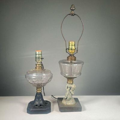 (2PC) GLASS OIL LAMPS | Two oil lamps, now electrified, including a glass oil lamp with cast painted metal base and a drilled lamp with...