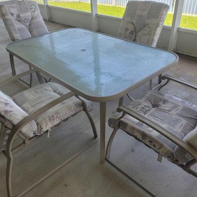 Lanai table with glass top and four chairs