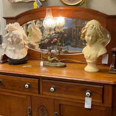 Sideboard with antique lamp with two different busts of ladies on each side 