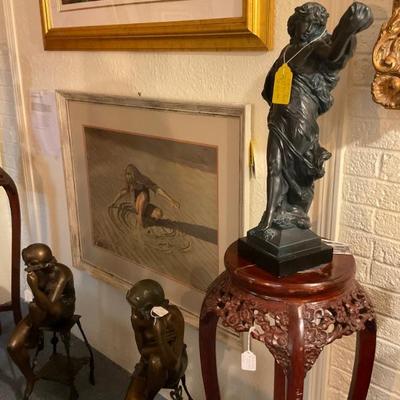 Three bronzes with girl playing in the sand print in the background. 