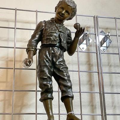 Large bronze boy playing with top