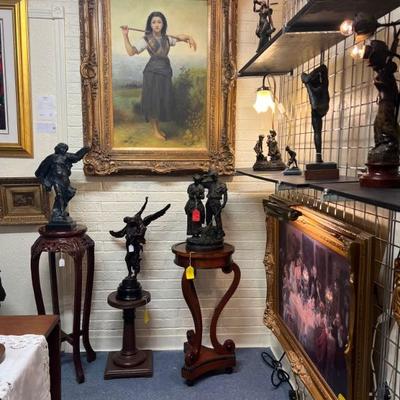 Gallery view with two paintings and several bronze figures.
