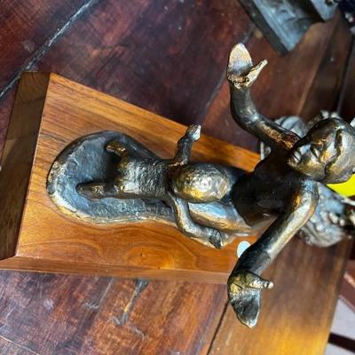 Bronze mother reaching out to embrace her child.