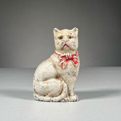 CAST IRON STILL BANK | With original paint, white cat still bank with red bow, held together by a screw in the back.
