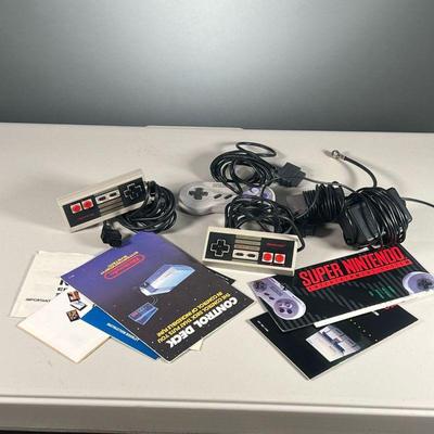 GROUP OF NINTENDO ACCESSORIES | Includes two NES controllers, an SNES controller, TV & power adapters, and instructional booklets.
