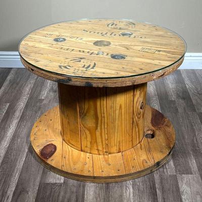 RUSTIC SOUTHWIRE SPOOL TABLE | Rustic wire spool form table painted with company logo and name “Southwire” with custom glass top. - h....