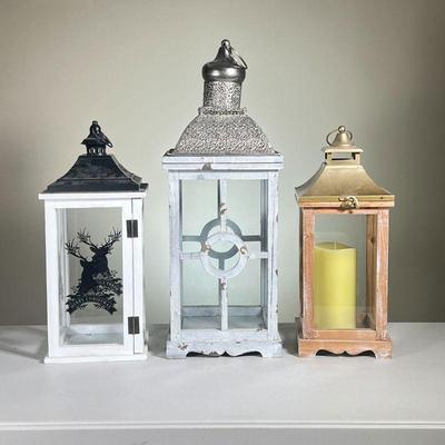 (3PC) DECORATIVE LANTERNS | Tallest Lantern with white Wood and a silver-toned metal top. Unfinished wood with gold toned metal top; and...