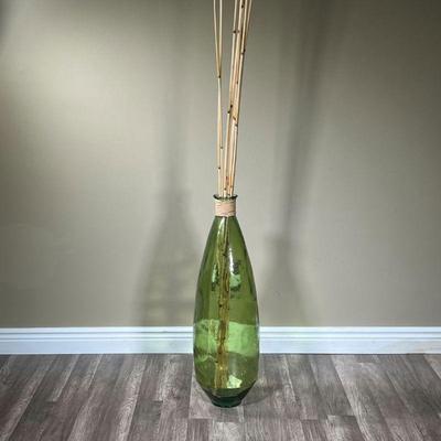 OVERSIZED DECORATIVE JAR | Large green glass jar with tall bamboo sticks sticking out the top. Bamboo approx. 83in. - h. 32 x dia. 9 in...