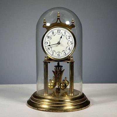 GERMAN SHELF CLOCK | In a glass dome, enameled dial with Arabic numerals. - h. 11 in