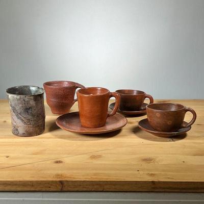 (5PC) MEG SMEAL ART POTTERY CUPS | Including a pair of cups with saucers, a single small mug with saucer, and two other cups. - h. 4 in...