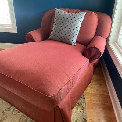 Upholstered chaise lounge, covered in garnet red fabric.  Round back scrolling arms and skirted seat.  In good condition, ready for your...