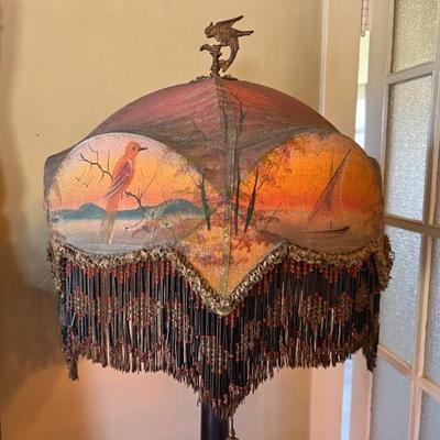 Fantastic antique floor lamp with elaborate decorated shade with long bead fringe, featuring a coastal water scene with a sailboat and birds