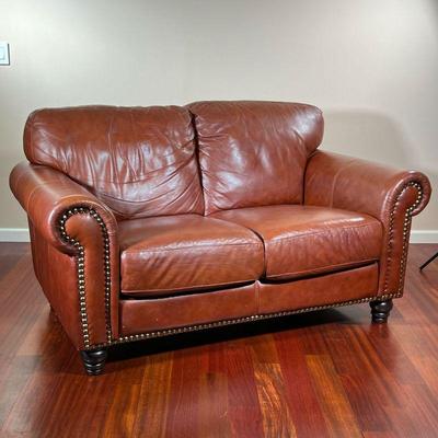 ITALIAN LEATHER LOVESEAT | Divani Chateau d'Ax small brown leather sofa with brass rivets on front border of armrests & base with spindle...