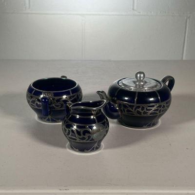 (3PC) SILVER OVERLAY TEA SET | Tea set in cark cobalt blue with silver overlay, comprising a teapot, open sugar, and open creamer. - l....